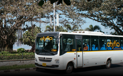 A Cityflo bus running in a green environment within Mumbai.